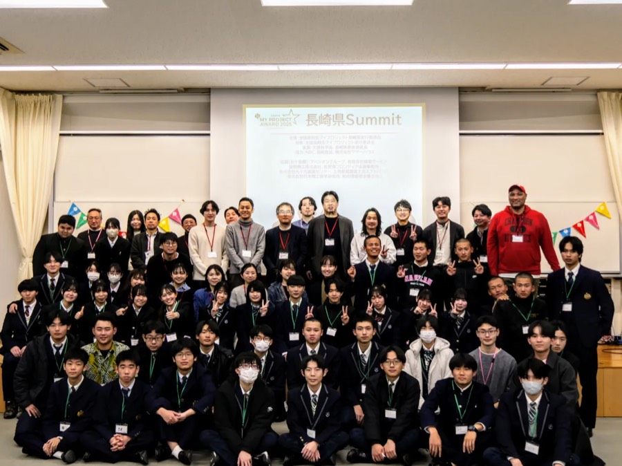 2025年度・長崎国際大学。県内8校から26プロジェクト・82名の高校生と、社会人サポーター23名。最後に全員で。